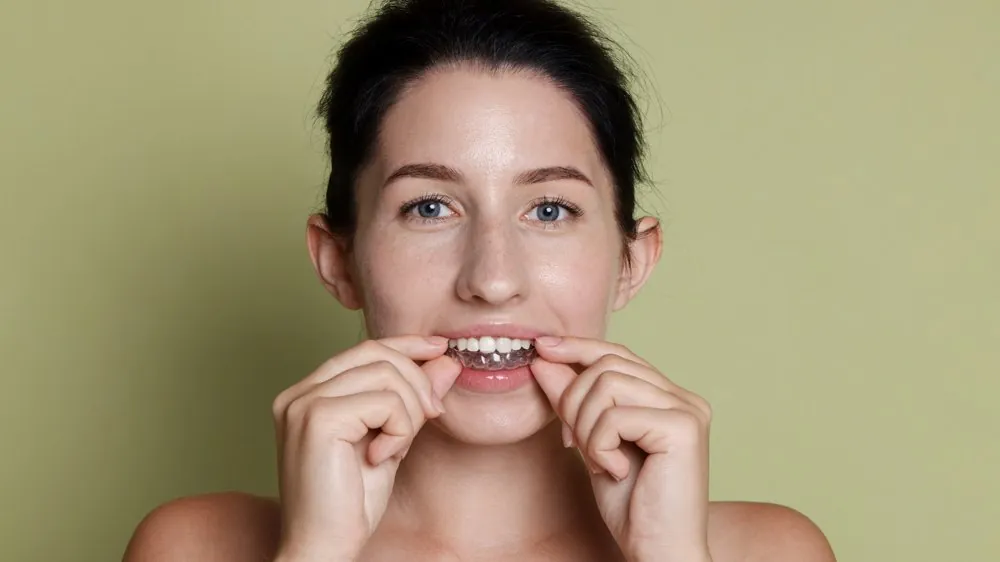 A woman placing a clear aligner